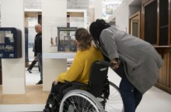 Femme en fauteuil roulant avec son accompagnatrice